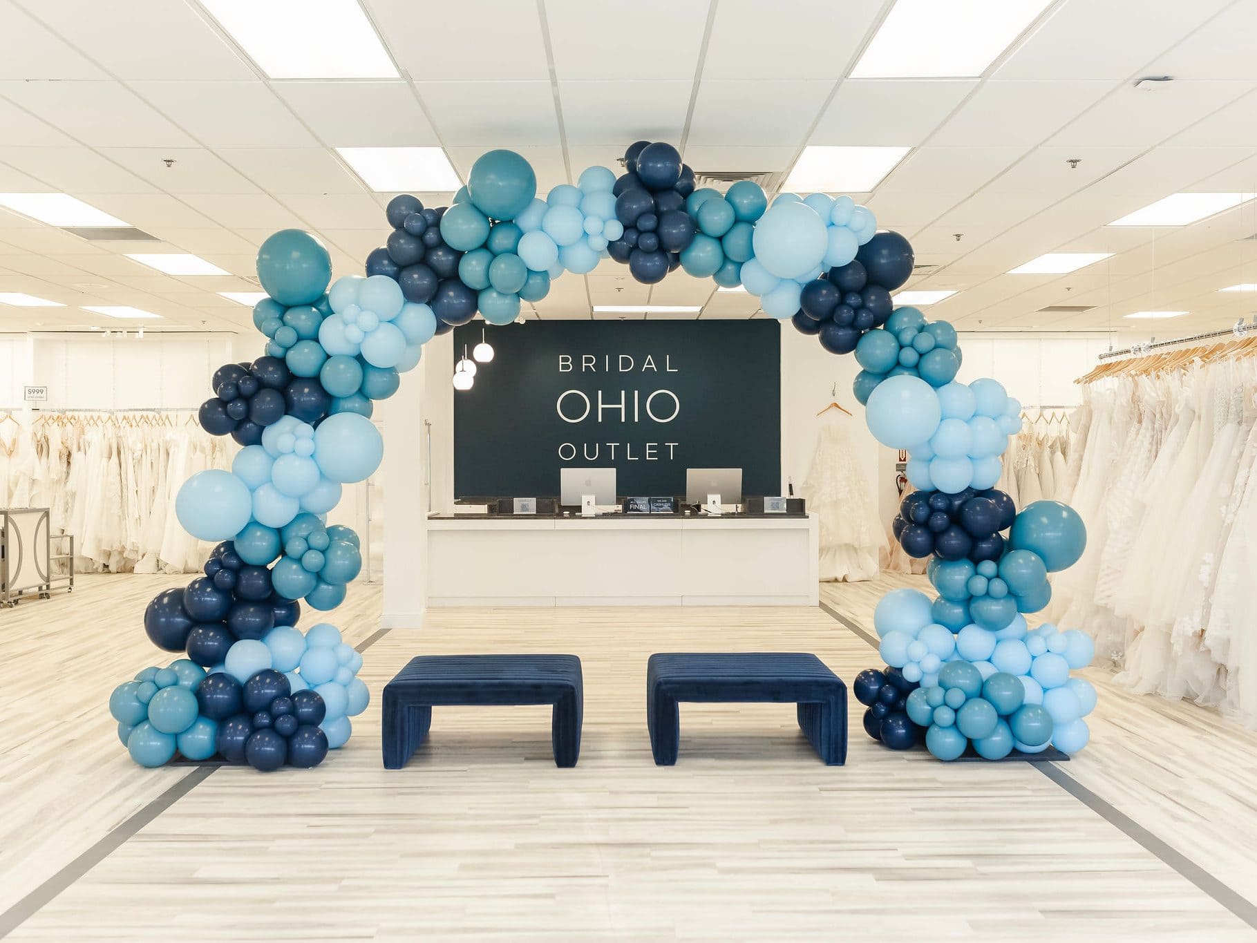 Balloon arch in shades of blue in front of cashwrap and seating